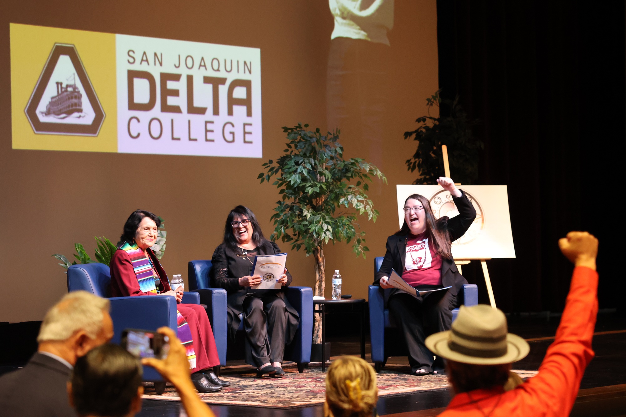Photo of audience members cheering as Dolores Huerta is introduced