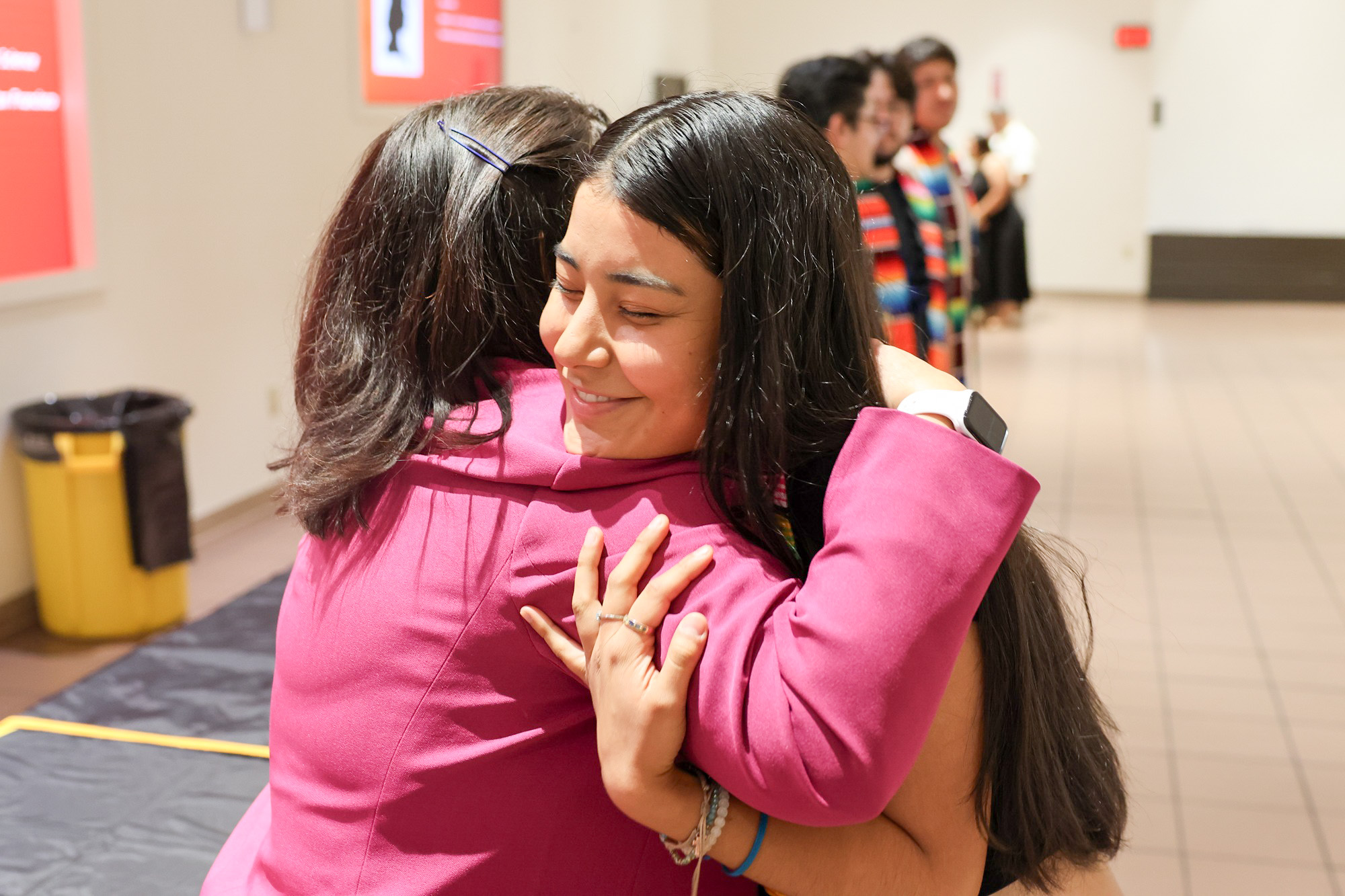 A Puente graduate gets a hug from Delta's superintendent/president