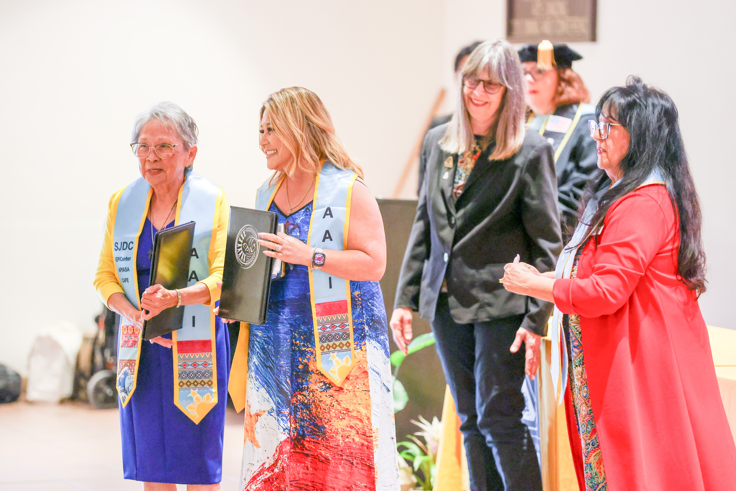 Photo of Veronica Smith and her daughter Virginia Ordaz being congratulated by Delta trustees