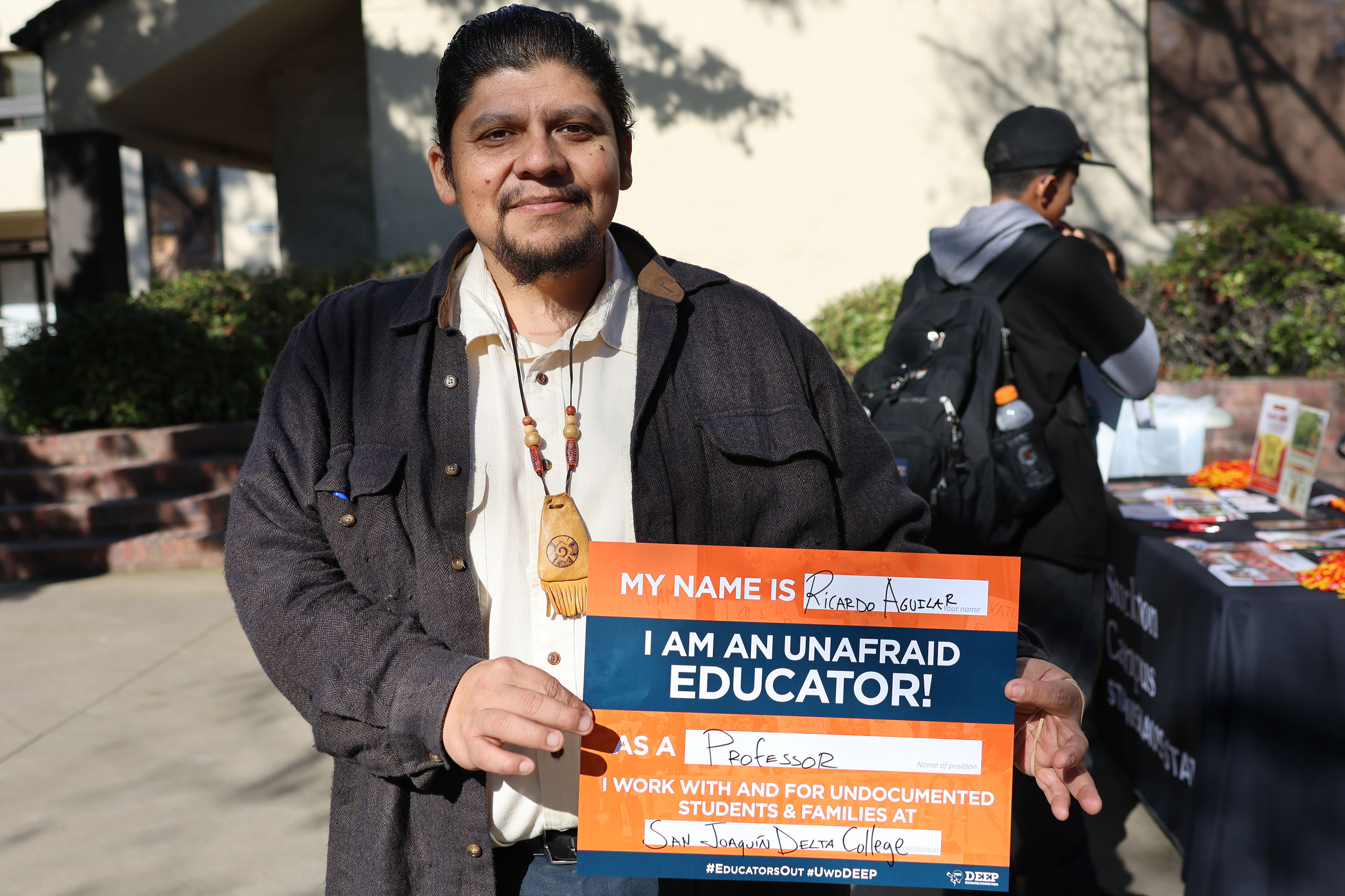Delta Professor, Ricardo Aguilar, holding sign supporting undocumented students