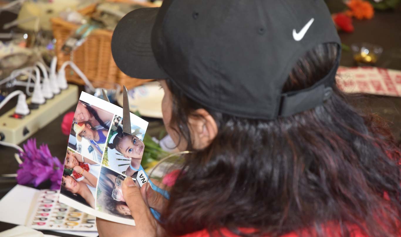 Vivian Medina cuts out a photo of her daughter, Valentina, for her Commencement cap. Vivian went to San Joaquin Delta College to help support Valentina.