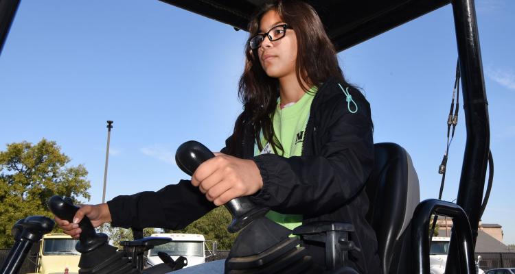 Young female student drives tractor
