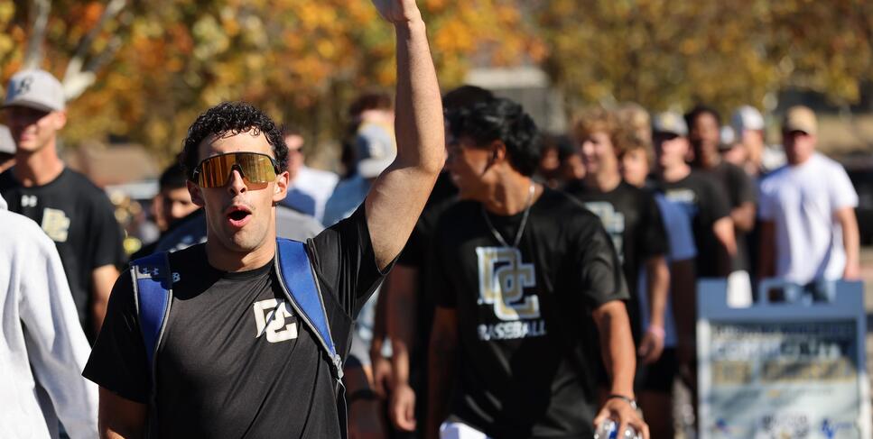 A Delta College athlete puts his arm in the air in celebration of Delta's new fields