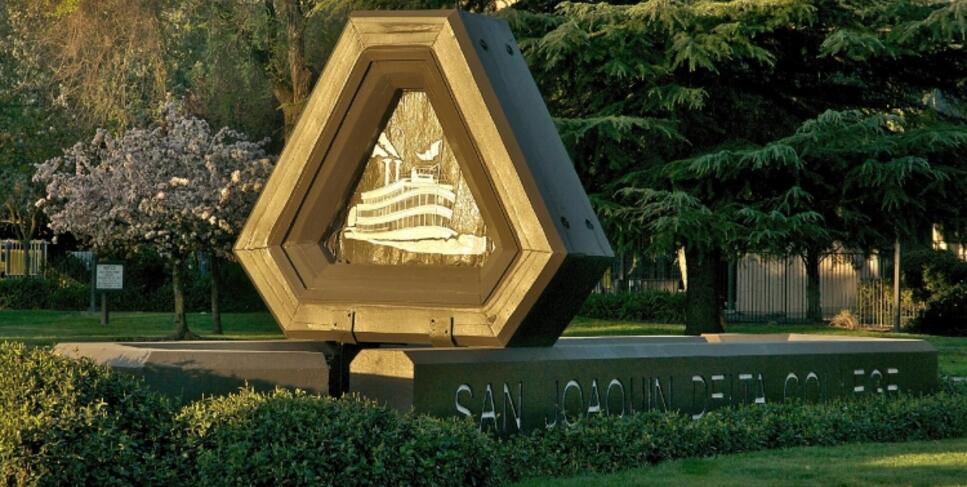 Photo of the Delta College steamboat sign at the Pacific Avenue entrance at sunrise