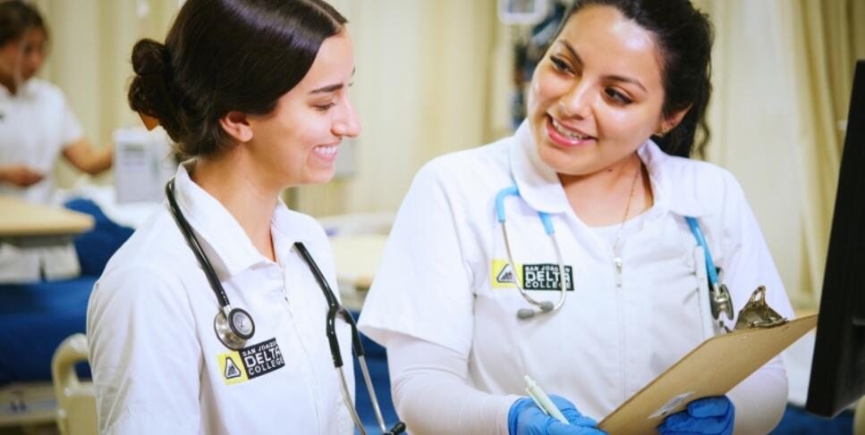 Two nursing students studying a patient's chart