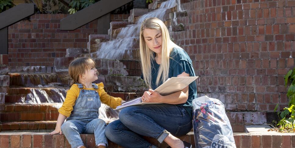 Photo of a student parent and her daughter studying at Budd
