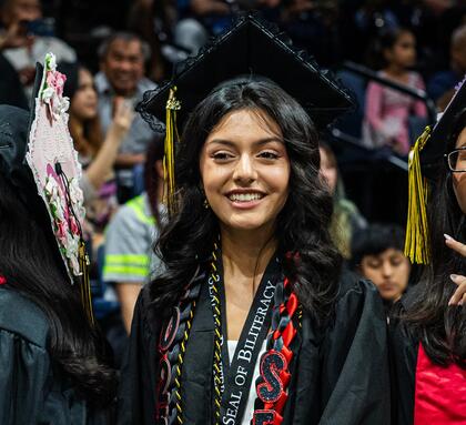Photo of a student graduating at Commencement