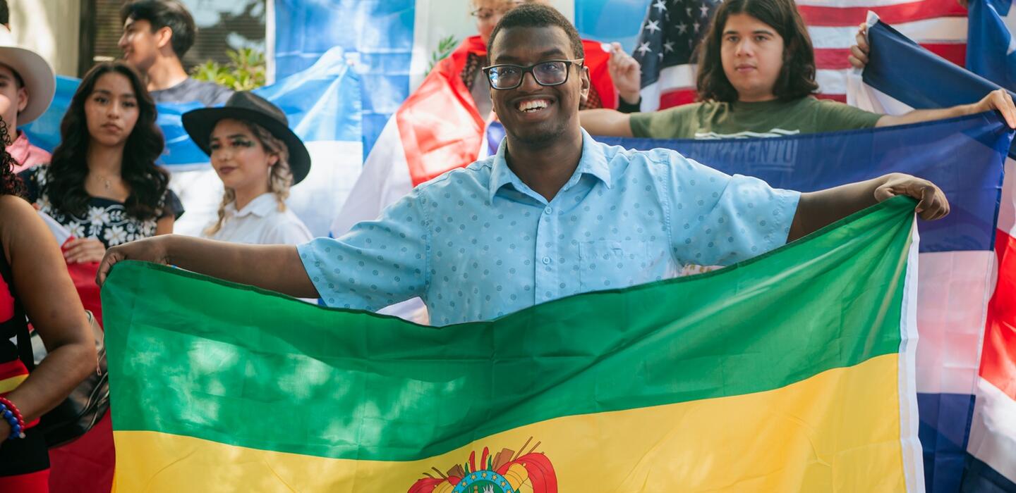 Students hold flags depicting their heritage at a Delta College event
