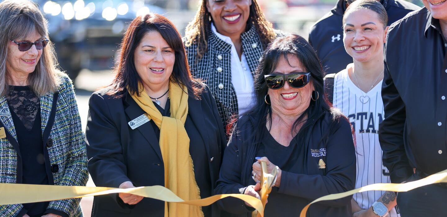 Photo of Board of Trustees President Janet Rivera cutting the ribbon at grand reopening of Delta's Chase Chevrolet Athletics Complex
