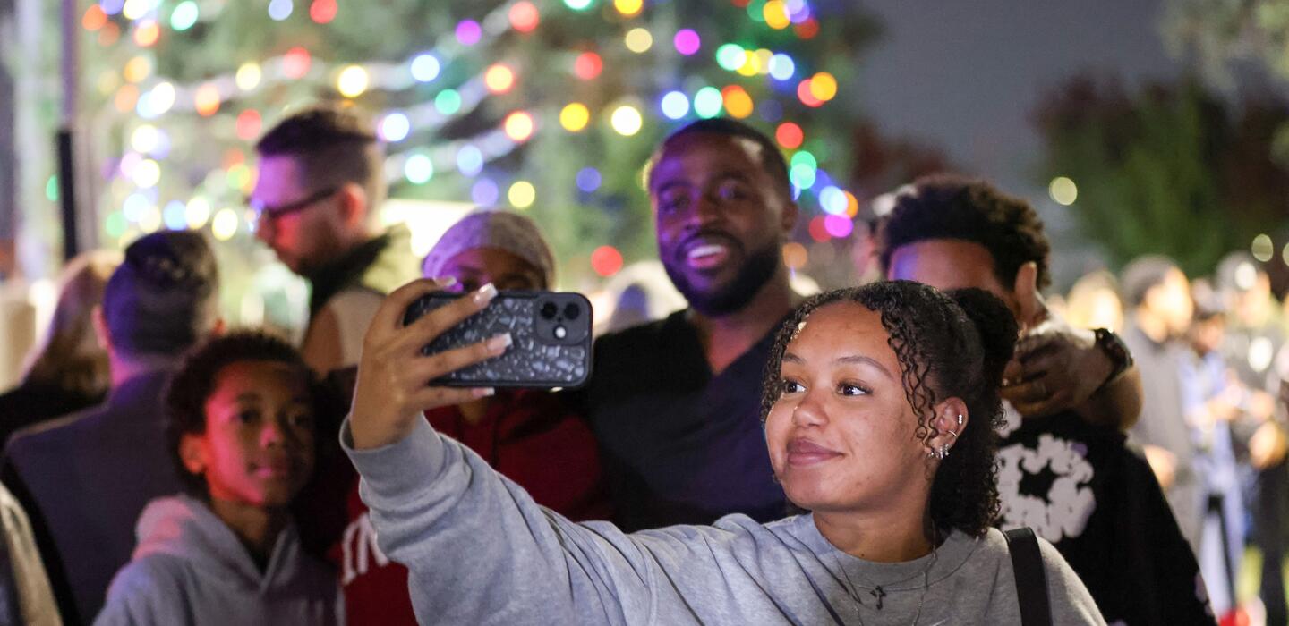 Photo of a family posing for a photo near the Tree of Lights