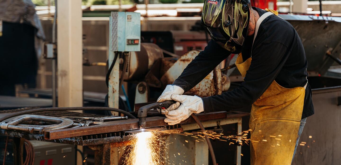 Photo of a welding student with sparks flying