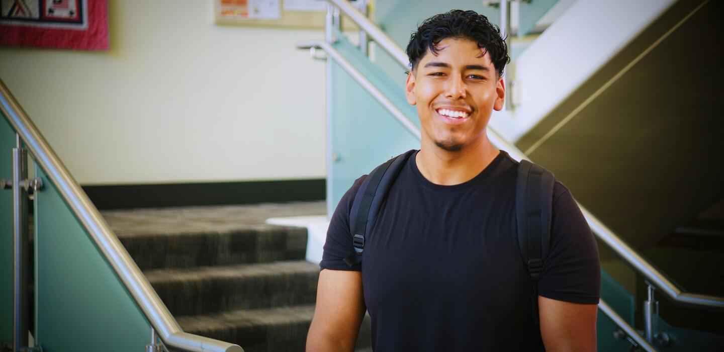 Photo of a student standing near the entrance to Goleman Library