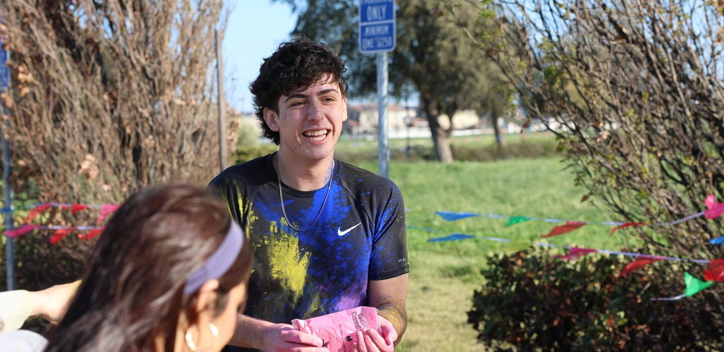 Photo of a student participating in Holi color splash event at Mountain House campus