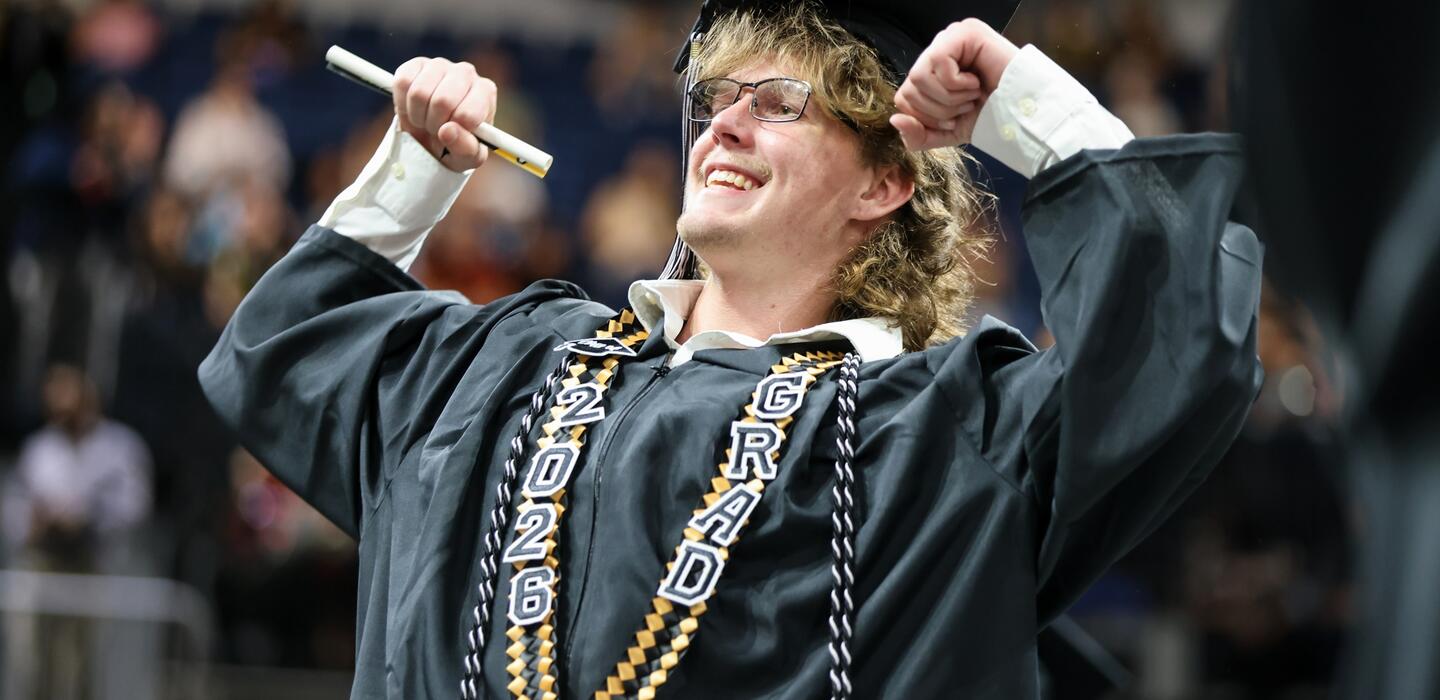Photo of a Delta graduate celebrating at Commencement