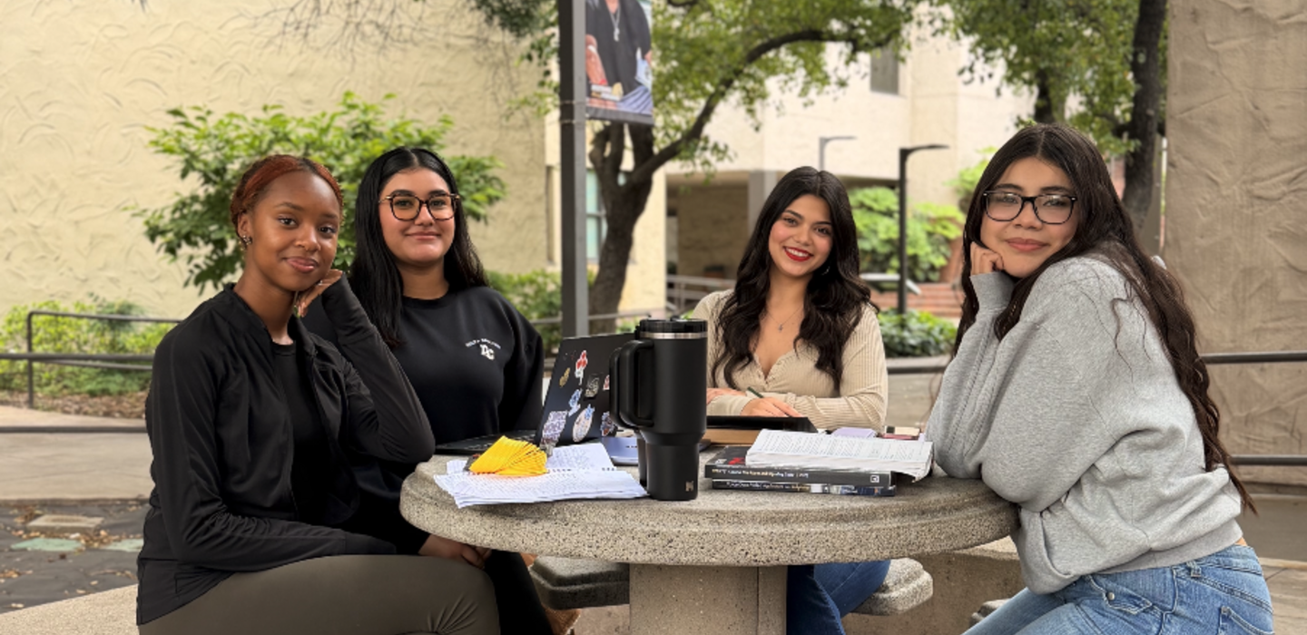 Student sitting at Table near Bookstore