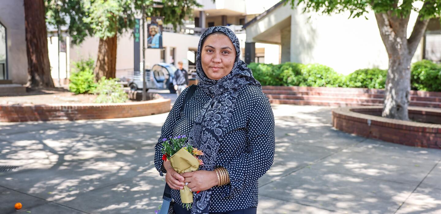 A student posing for a photo in the quad