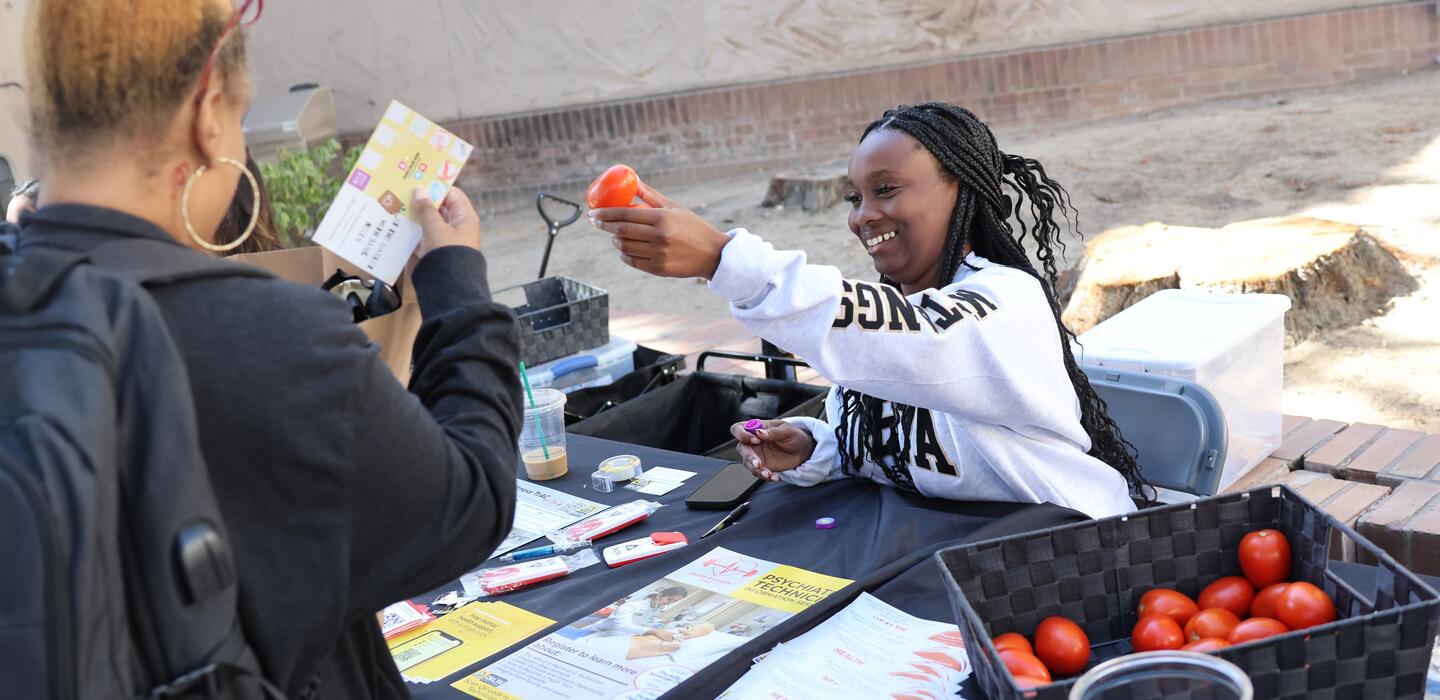 Photo of a student distributing food at a farmer's market