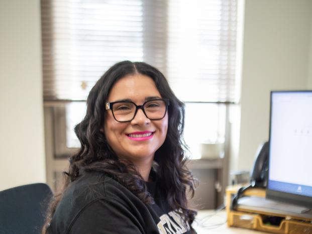 Counselor sitting at desk and smiling