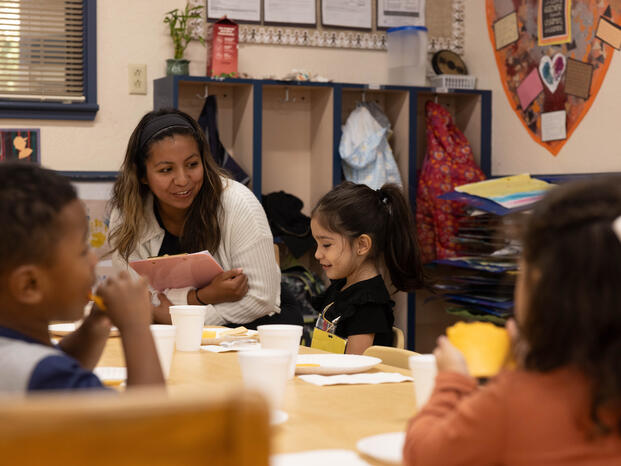 Children's classroom with educator assisting student
