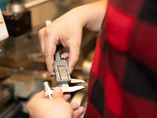 student with a caliper