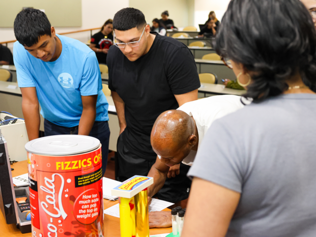 students on the table looking to the objects and taking notes