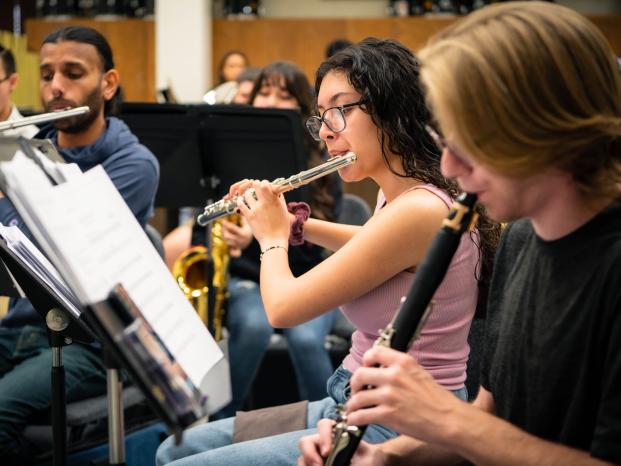 Students joyfully playing various instruments together in a lively chorus practice..