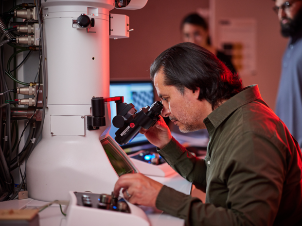 a person looking through the high-end microscopy