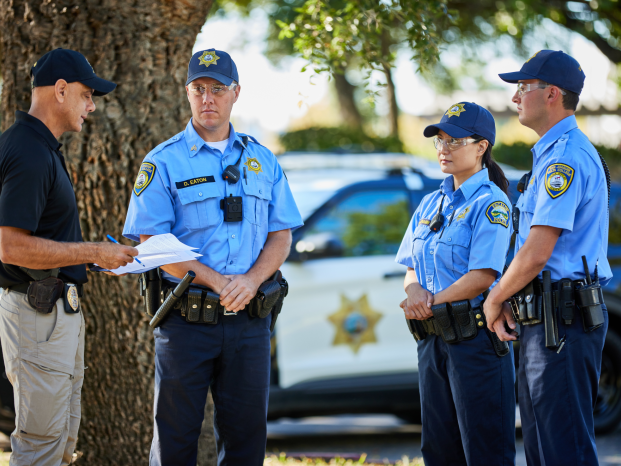 New police officers are listening to a veteran officer's briefing 