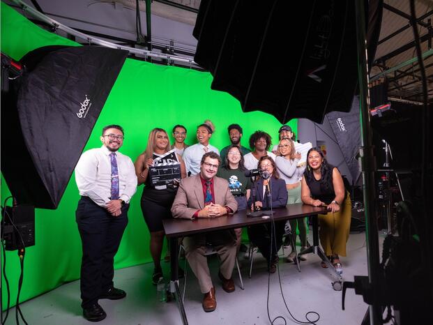 journalists in front of the cameras with the green background