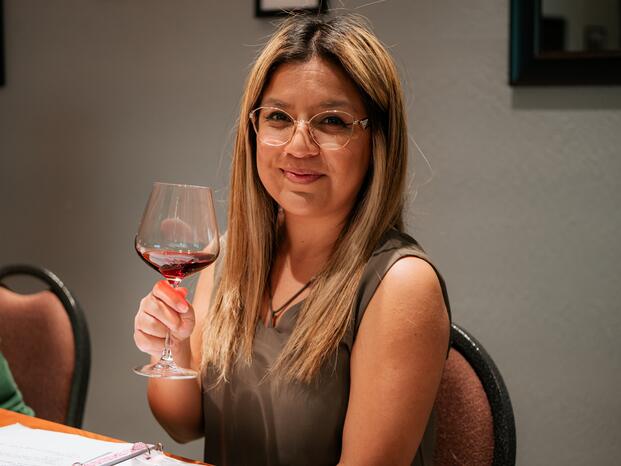 A wine hospitality student takes a sip of wine