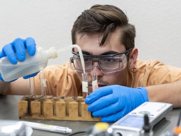 A chemistry student works with test tubes.