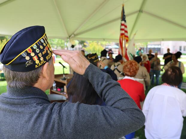A veteran salutes the flag during a Delta College ceremony