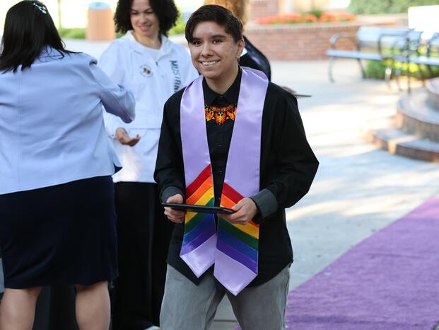 Student graduate with certificate at Lavender Graduation