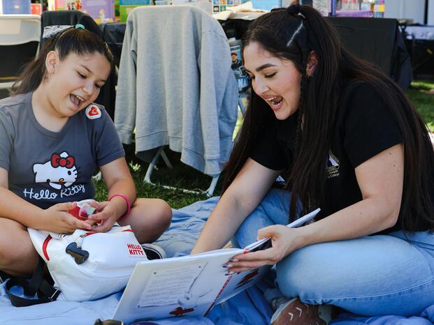 Woman helping child read and speak