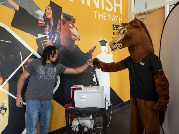 Fierce the Mustang gets a high five at the Delta Connect Center