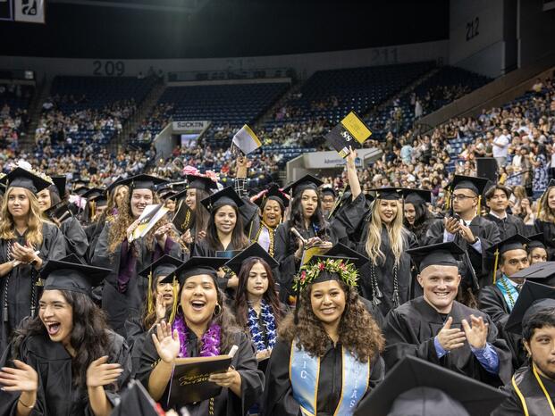 Delta grads celebrating at Commencement ceremony wearing their caps and gowns
