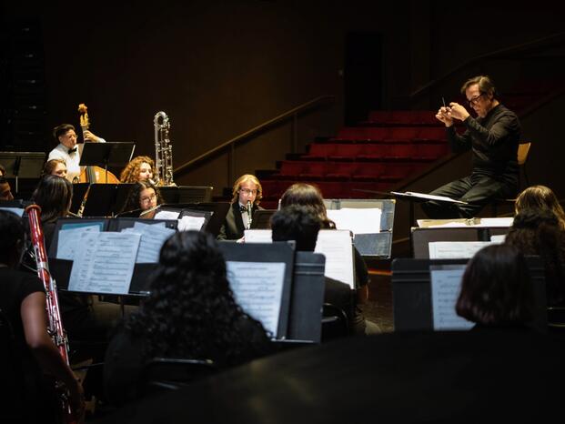 Student in Auditorium playing Music
