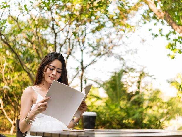 A student reads student work in a magazine