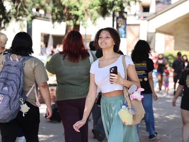 Photo of a student walking through the Delta College quad