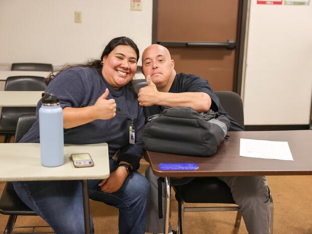 A DSPS student smiles during class and gives a thumbs up