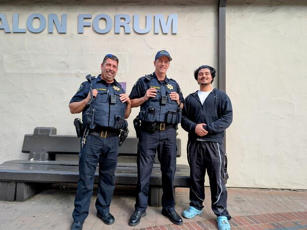 Two Delta College police officers pose for a photo with a student