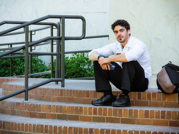 A nursing student takes a break on the steps outside the Locke Center