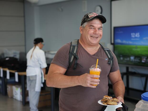 Photo of an EOPS student picking up swag at an event.