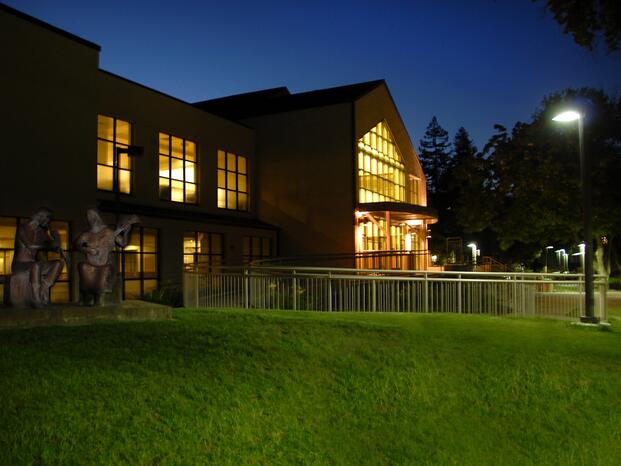 A photo of the Goleman Library illuminated at night