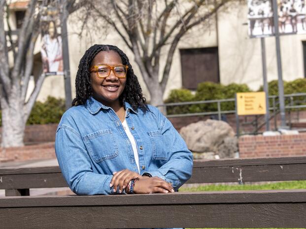 Photo of a student on the bridge by the Koi pond