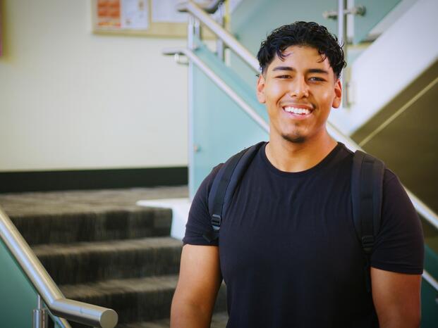 Photo of a student standing near the entrance to Goleman Library