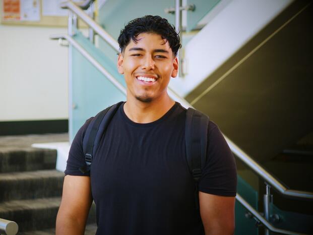 Photo of a student standing near the entrance to Goleman Library