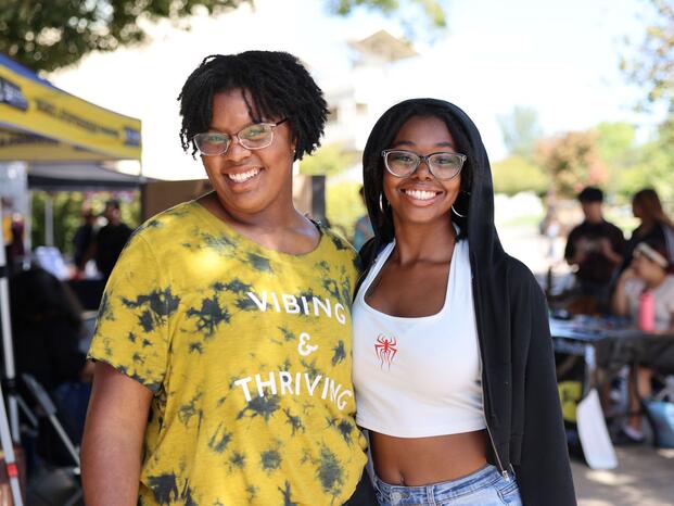Students smiling while tabling at Club Rush event