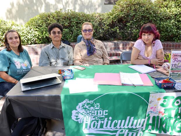 Students smiling while tabling at Club Rush event