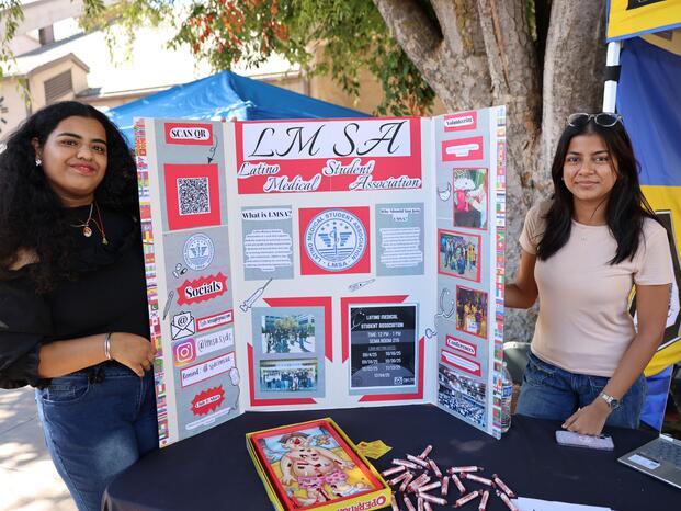 Students holding a trifold with information on the Latino Medical Sudent Association